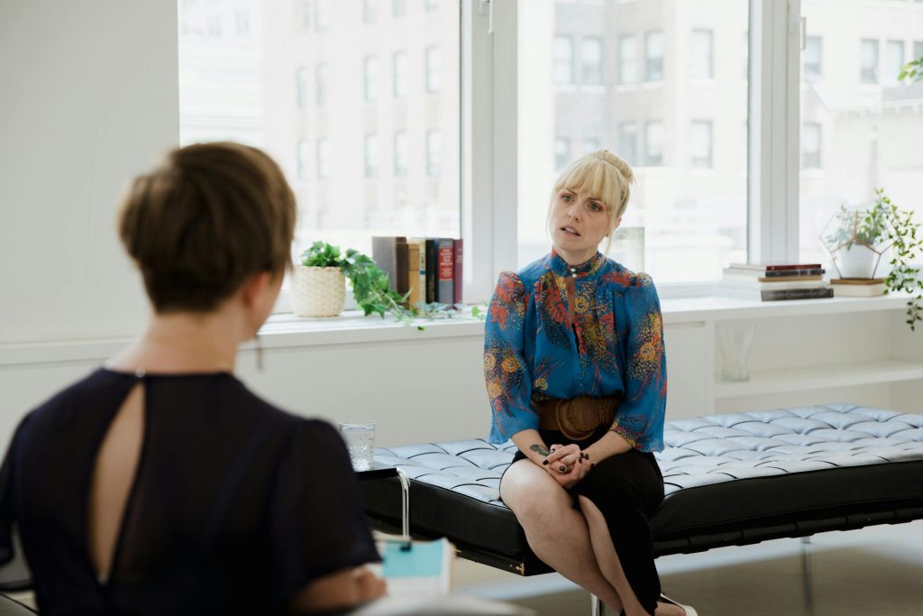 A woman engages in a wellness session with her counselor in a bright, modern office.
